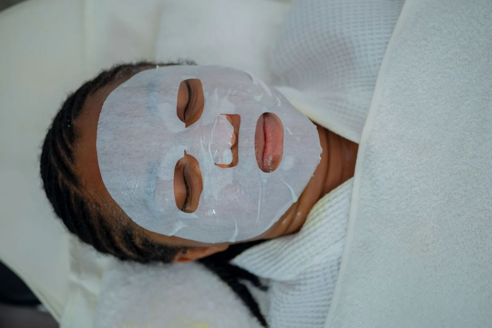 Woman enjoying a rejuvenating facial mask treatment at a spa in Abuja, Nigeria.